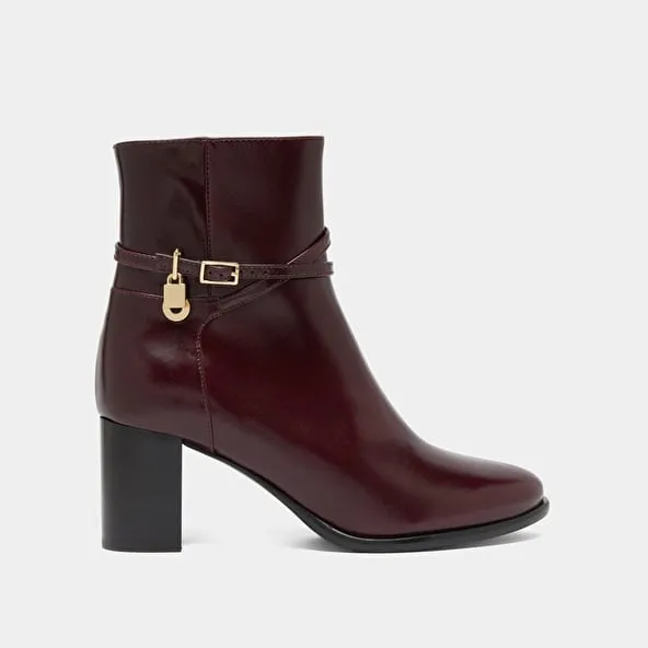 Boots with high heels and gold charms in burgundy leather