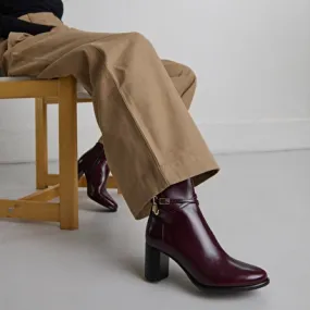 Boots with high heels and gold charms in burgundy leather