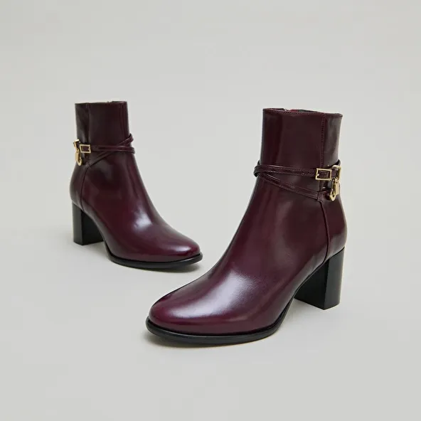 Boots with high heels and gold charms in burgundy leather