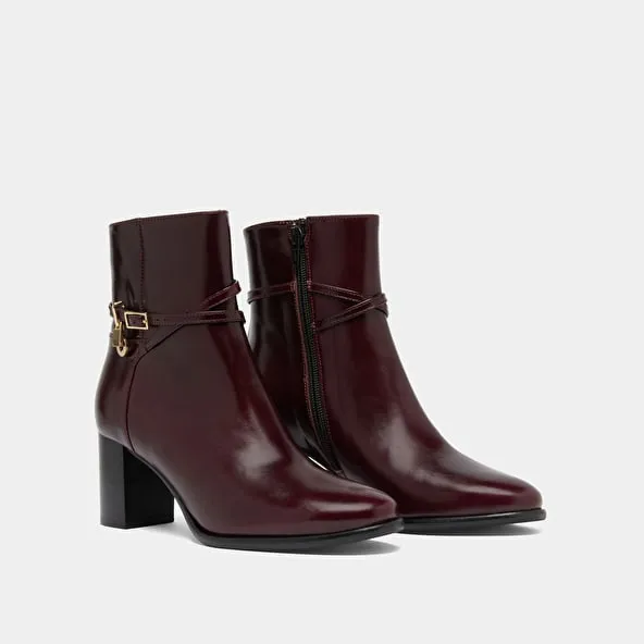 Boots with high heels and gold charms in burgundy leather