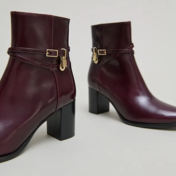 Boots with high heels and gold charms in burgundy leather