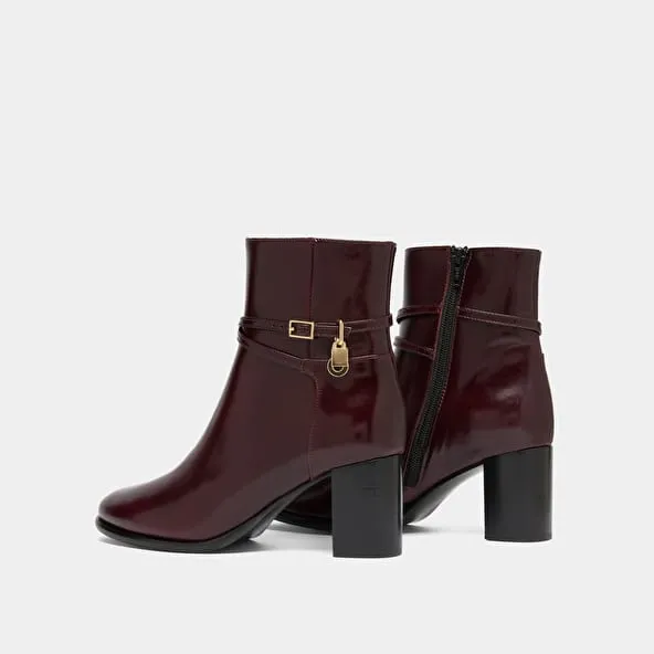 Boots with high heels and gold charms in burgundy leather