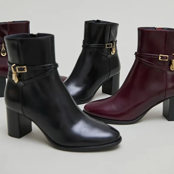 Boots with high heels and gold charms in burgundy leather